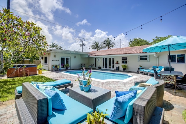 pool featuring french doors, outdoor lounge area, a hot tub, and a patio