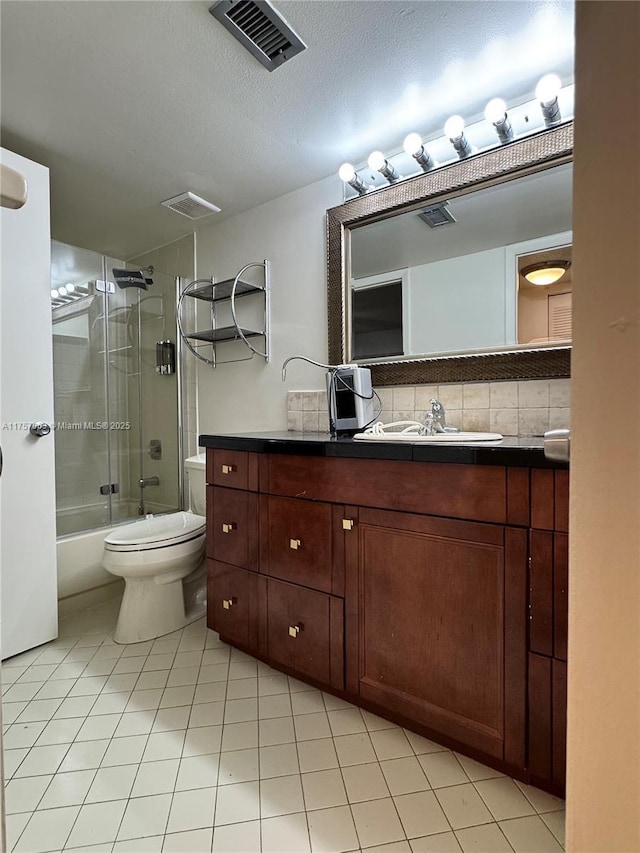 full bath featuring shower / bath combination with glass door, vanity, a textured ceiling, toilet, and visible vents