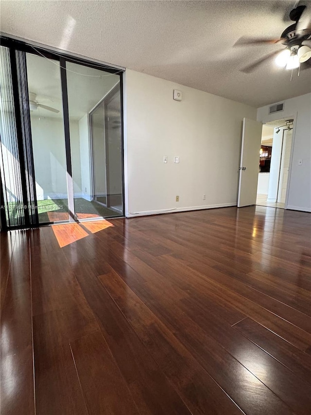 empty room with visible vents, a ceiling fan, and wood-type flooring