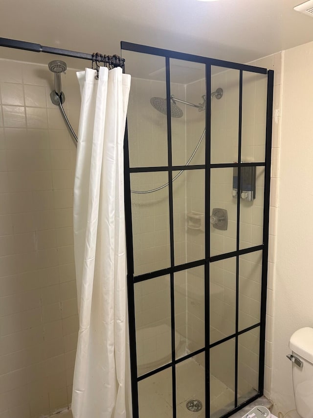 bathroom featuring visible vents, toilet, and a shower stall