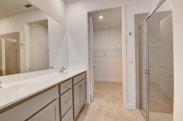6975 Peters Ln, Delray Beach, FL 33446 - bathroom with a spacious closet, visible vents, double vanity, a stall shower, and a sink
