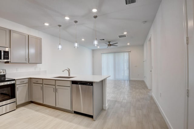 6975 Peters Ln, Delray Beach, FL 33446 - kitchen featuring a peninsula, gray cabinetry, a sink, light countertops, and appliances with stainless steel finishes