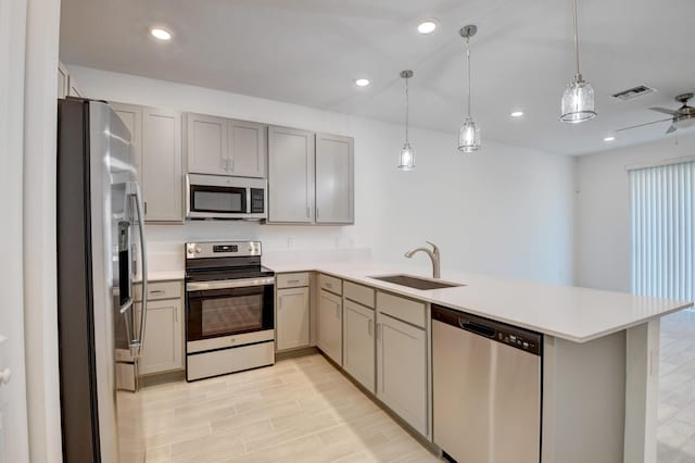 6975 Peters Ln, Delray Beach, FL 33446 - kitchen with visible vents, a sink, appliances with stainless steel finishes, a peninsula, and light wood finished floors