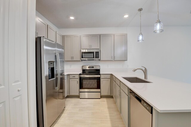 6975 Peters Ln, Delray Beach, FL 33446 - kitchen featuring light countertops, gray cabinets, appliances with stainless steel finishes, a peninsula, and a sink