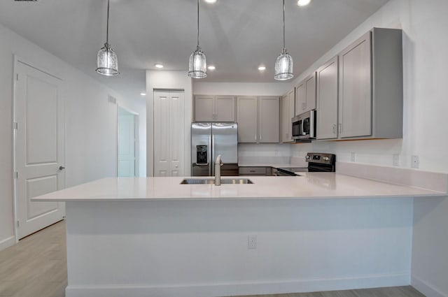 6975 Peters Ln, Delray Beach, FL 33446 - kitchen with gray cabinetry, light wood-style flooring, a sink, appliances with stainless steel finishes, and light countertops