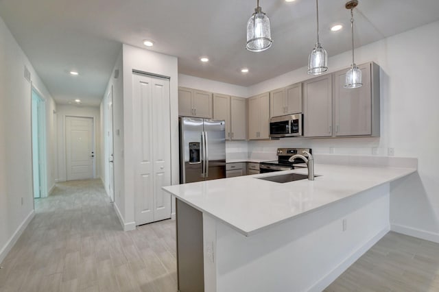 6975 Peters Ln, Delray Beach, FL 33446 - kitchen with gray cabinetry, light countertops, a peninsula, stainless steel appliances, and a sink