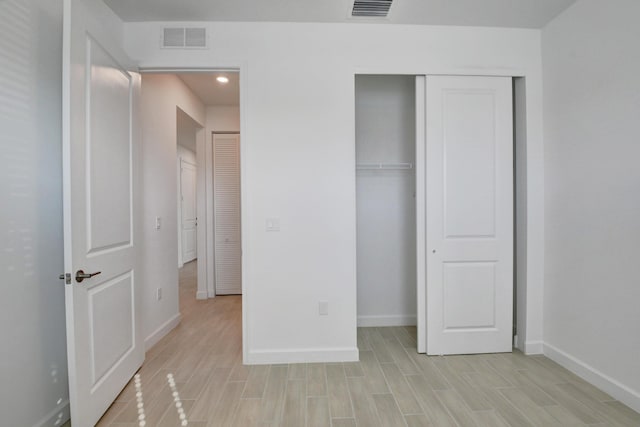 6975 Peters Ln, Delray Beach, FL 33446 - unfurnished bedroom featuring a closet, visible vents, baseboards, and wood tiled floor