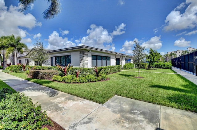 6975 Peters Ln, Delray Beach, FL 33446 - view of home's exterior with stone siding, stucco siding, a lawn, and fence