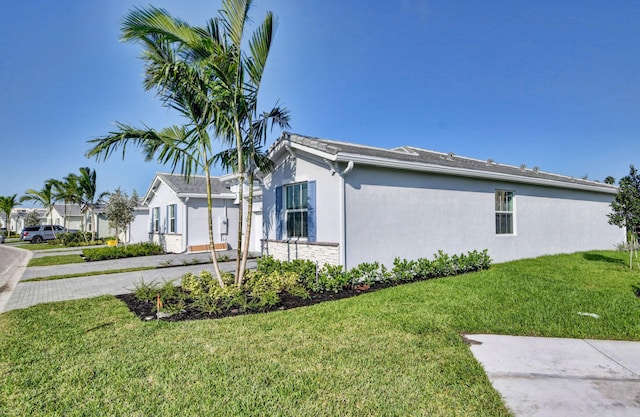 6975 Peters Ln, Delray Beach, FL 33446 - view of property exterior with stucco siding and a lawn