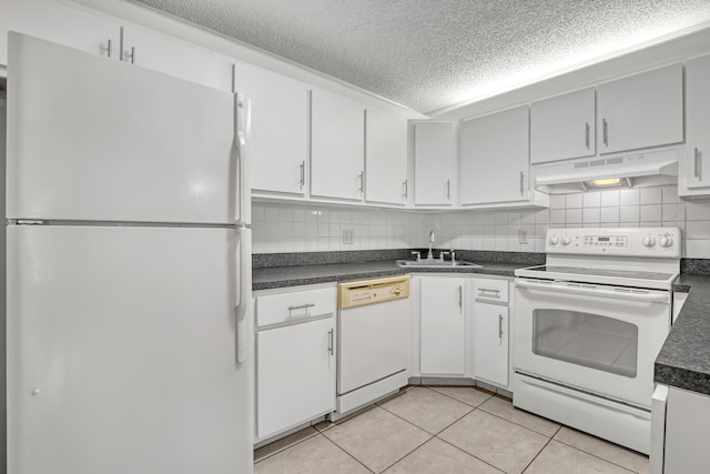 436 Pine Glen Ln Unit C-2, Greenacres, FL 33463 - kitchen with under cabinet range hood, a sink, dark countertops, white appliances, and light tile patterned flooring