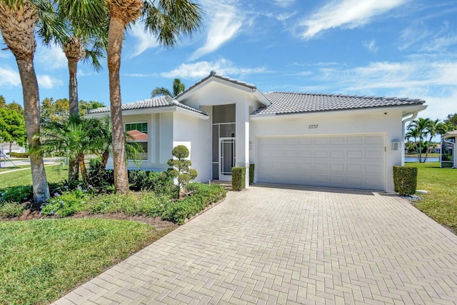 2737 Clipper Cir, West Palm Beach, FL 33411 - view of front of home with a tile roof, an attached garage, decorative driveway, and stucco siding