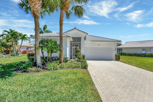 2737 Clipper Cir, West Palm Beach, FL 33411 - view of front of home featuring a garage, a tiled roof, decorative driveway, and a front yard