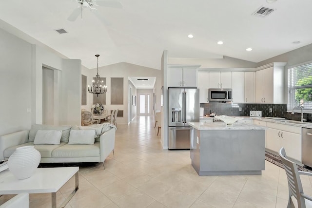 2737 Clipper Cir, West Palm Beach, FL 33411 - kitchen with stainless steel appliances, vaulted ceiling, a sink, tasteful backsplash, and a chandelier