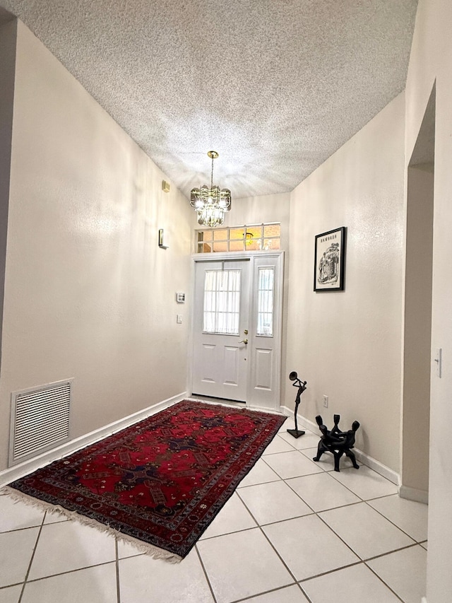 434 SE Doat St, Port Saint Lucie, FL 34983 - entryway with a textured ceiling, light tile patterned floors, baseboards, visible vents, and an inviting chandelier