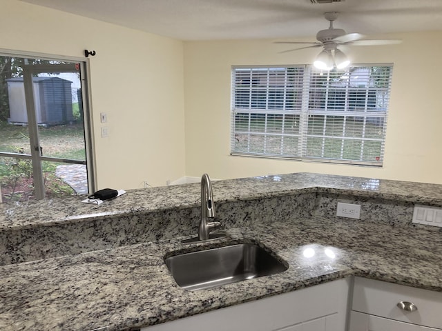 1112 Wild Cherry Ln, Wellington, FL 33414 - kitchen with a ceiling fan, visible vents, stone countertops, a sink, and white cabinetry