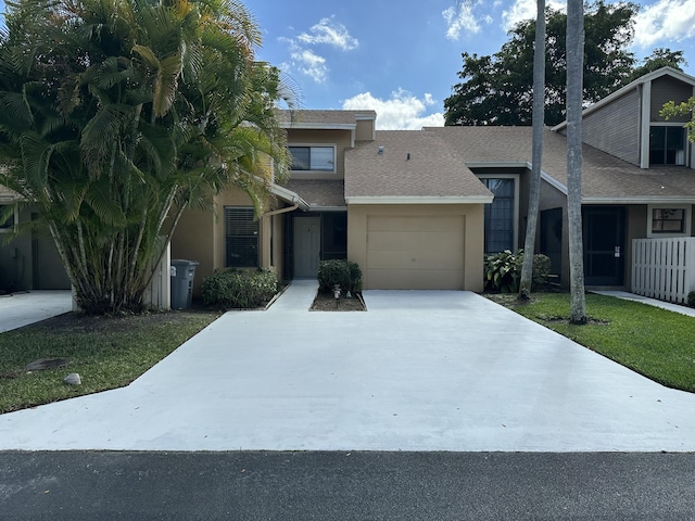 view of front of house with stucco siding, driveway, and a garage