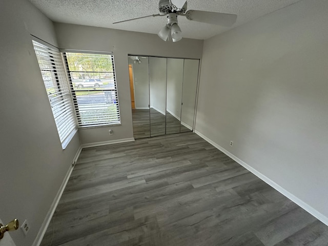 unfurnished bedroom featuring a ceiling fan, wood finished floors, baseboards, a closet, and a textured ceiling