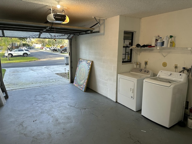 garage with washer and dryer, a garage door opener, and concrete block wall