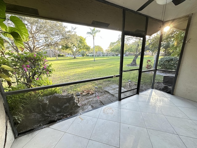unfurnished sunroom with ceiling fan