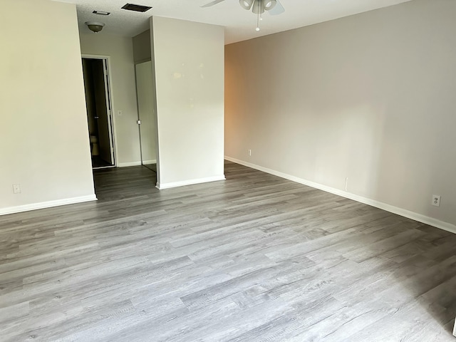 empty room with wood finished floors, baseboards, and ceiling fan