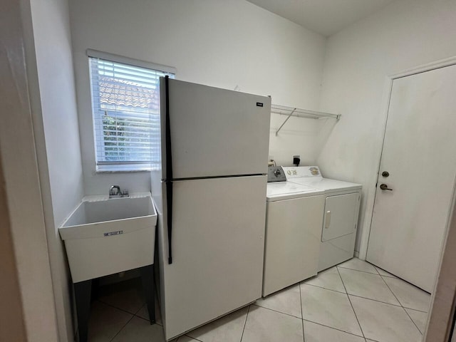 laundry room featuring separate washer and dryer and light tile patterned flooring