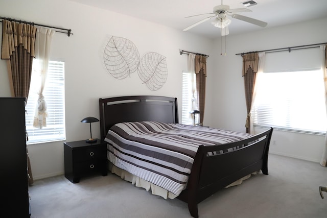 bedroom featuring light colored carpet, baseboards, and ceiling fan
