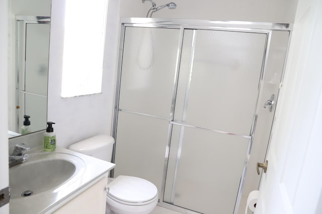 full bath with toilet, vanity, and a stall shower