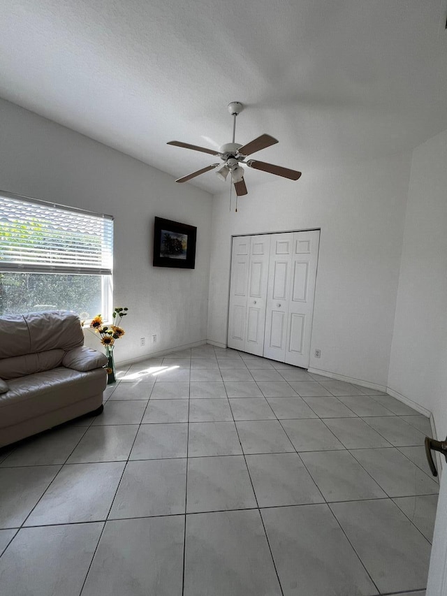 living area featuring a ceiling fan and light tile patterned flooring