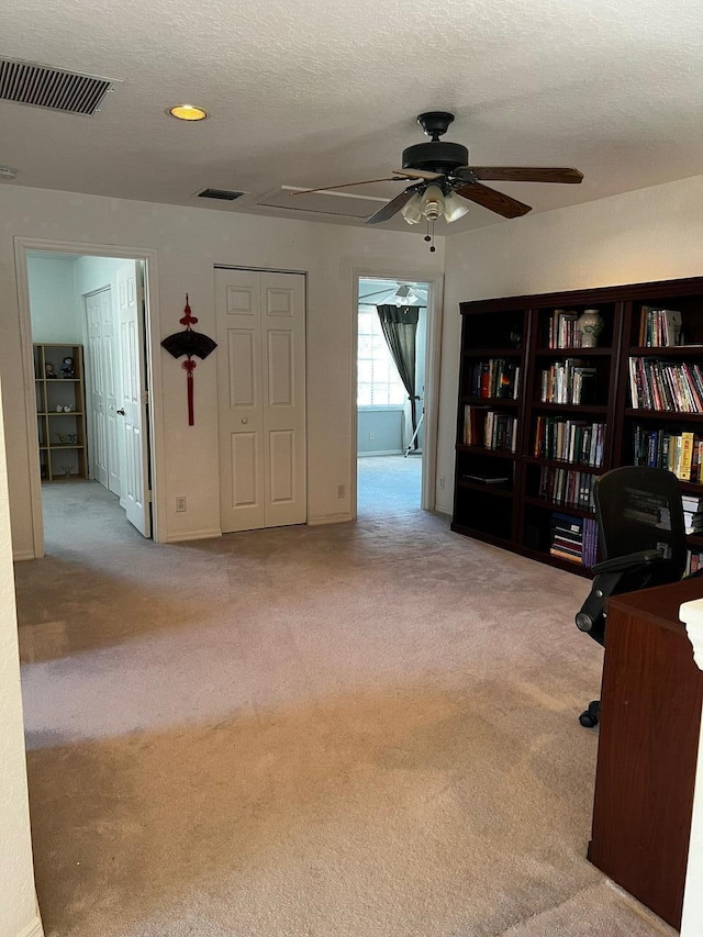 unfurnished office featuring carpet and a ceiling fan