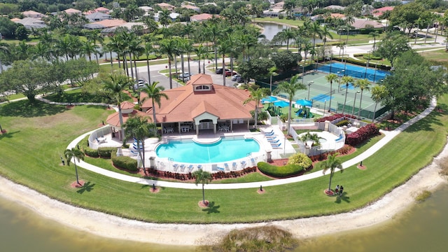 drone / aerial view of a pool area and a nearby body of water