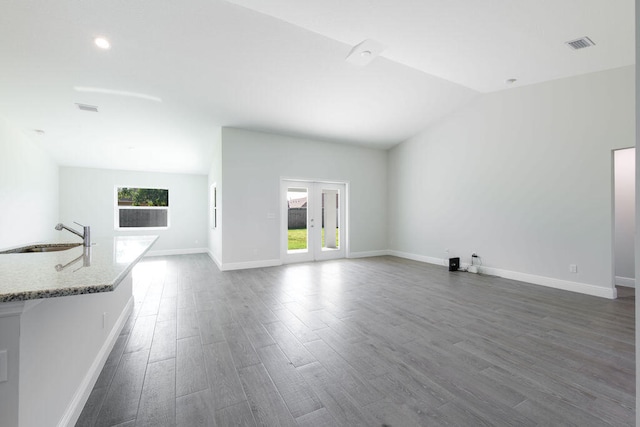 2372 SW Import Dr, Port Saint Lucie, FL 34953 - unfurnished living room with visible vents, baseboards, a sink, dark wood-type flooring, and lofted ceiling