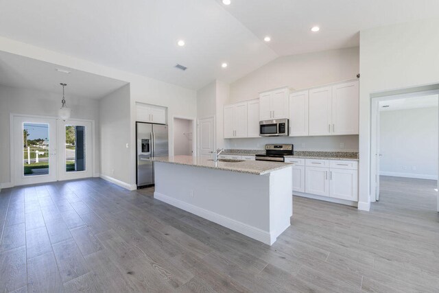 2372 SW Import Dr, Port Saint Lucie, FL 34953 - kitchen with baseboards, white cabinetry, a kitchen island with sink, visible vents, and appliances with stainless steel finishes