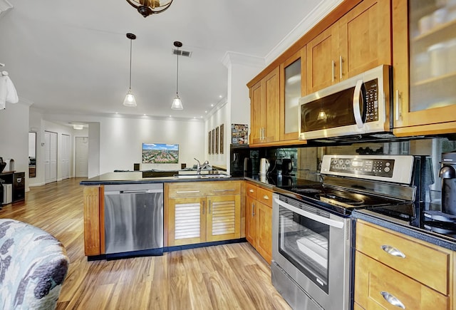 kitchen with dark countertops, visible vents, a peninsula, stainless steel appliances, and a sink