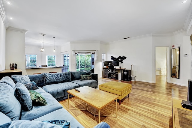 living room featuring visible vents, baseboards, light wood-style flooring, and crown molding