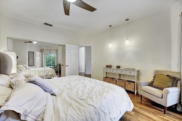 bedroom with visible vents, a ceiling fan, and wood finished floors