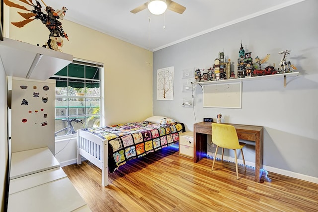 bedroom with ornamental molding, ceiling fan, baseboards, and wood finished floors