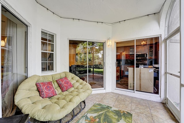 sunroom featuring tile patterned floors and outdoor lounge area