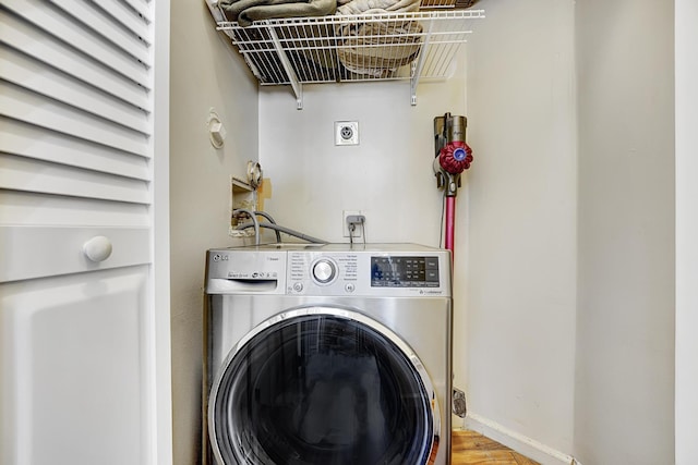 laundry room with baseboards, washer / clothes dryer, and laundry area