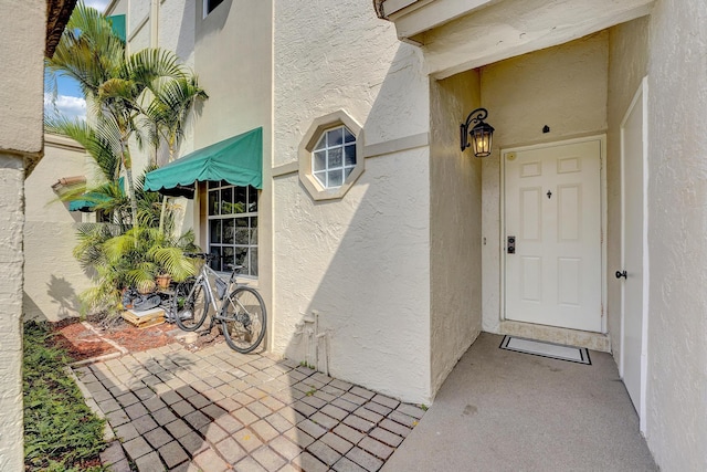 doorway to property featuring stucco siding and a patio area