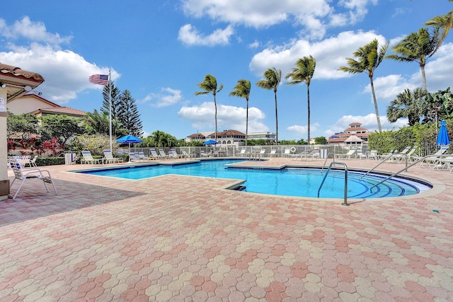pool with a patio and fence