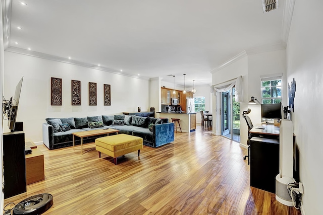 living area with recessed lighting, light wood-style floors, visible vents, and ornamental molding