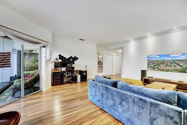living room with crown molding, light wood-style flooring, and baseboards