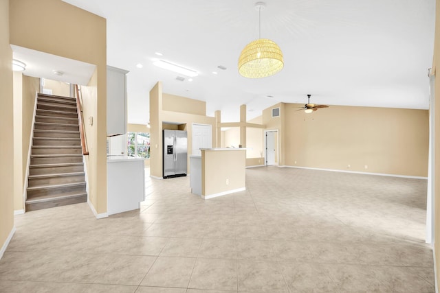 1355 SW Porter Rd, Port Saint Lucie, FL 34953 - unfurnished living room featuring baseboards, stairs, ceiling fan, lofted ceiling, and light tile patterned floors