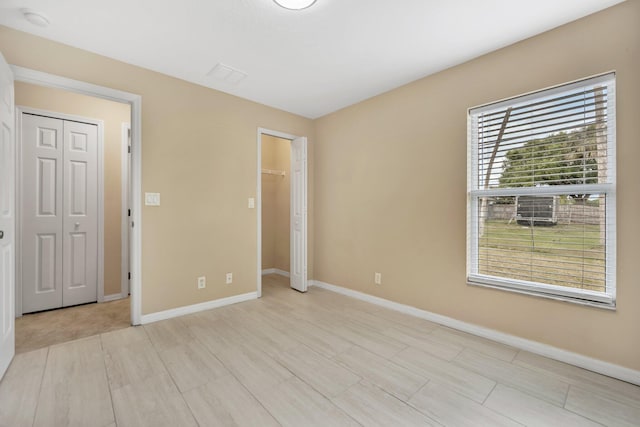 1355 SW Porter Rd, Port Saint Lucie, FL 34953 - unfurnished bedroom with baseboards, a spacious closet, and a closet