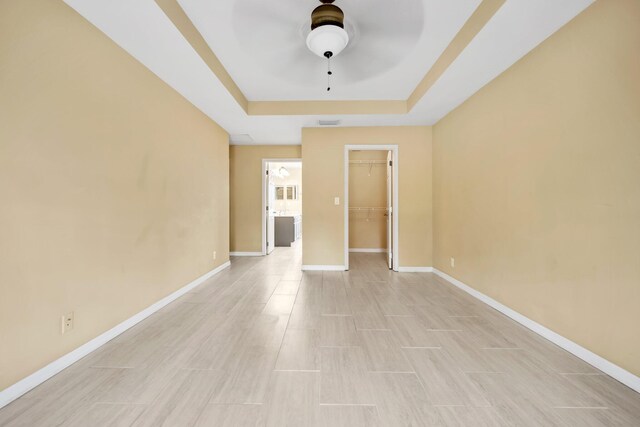 1355 SW Porter Rd, Port Saint Lucie, FL 34953 - empty room with a tray ceiling, baseboards, light wood-style floors, visible vents, and ceiling fan