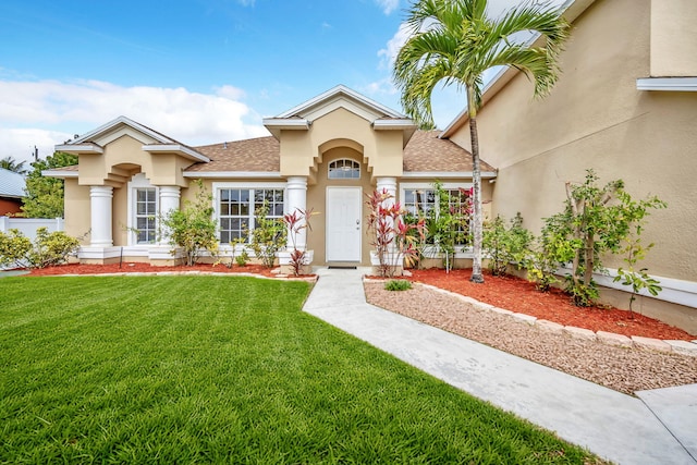 1355 SW Porter Rd, Port Saint Lucie, FL 34953 - mediterranean / spanish home featuring a front yard, stucco siding, and a shingled roof