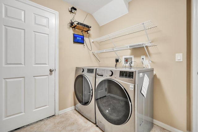 1355 SW Porter Rd, Port Saint Lucie, FL 34953 - clothes washing area with light tile patterned flooring, baseboards, washing machine and clothes dryer, and laundry area