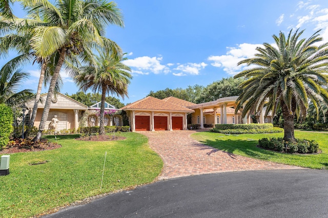 16090 Rio Del Paz, Delray Beach, FL 33446 - mediterranean / spanish home with an attached garage, decorative driveway, a front lawn, a tile roof, and stucco siding