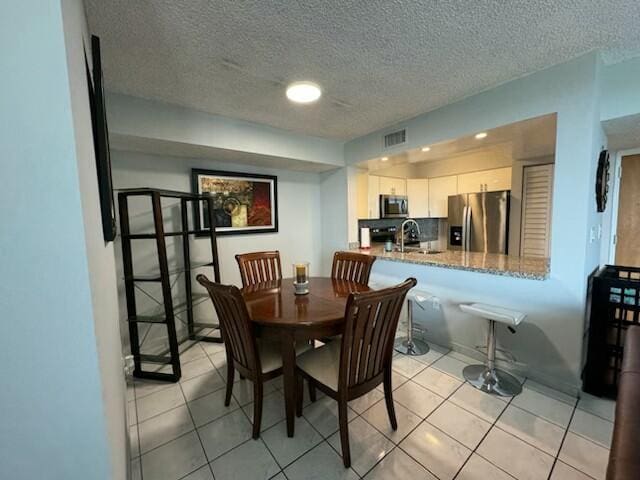 2075 SW 122nd Ave Unit 513, Miami, FL 33175 - dining space with a textured ceiling, visible vents, and light tile patterned floors