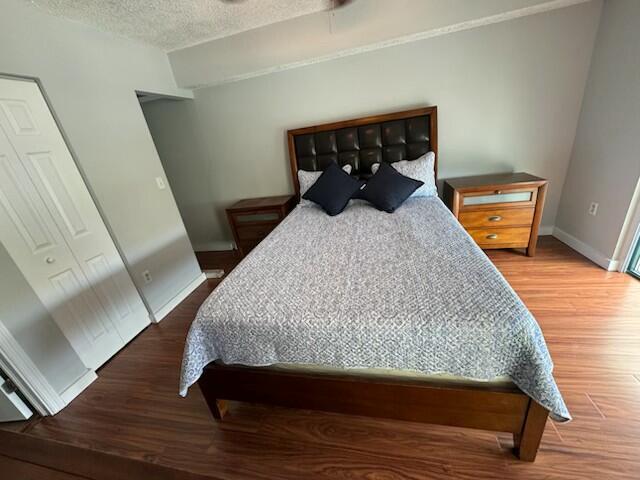 2075 SW 122nd Ave Unit 513, Miami, FL 33175 - bedroom featuring a textured ceiling, baseboards, and wood finished floors